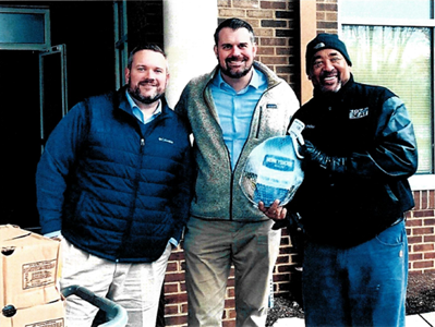Photo of attorneys Hicks and Funfsinn delivering frozen turkeys to First Baptist Church Bracktown in Lexington with Jay Alexander from 107.9 The Beat.