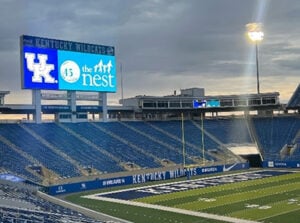 Photo of University of Kentucky football field with The Nest image advertised on scoreboard