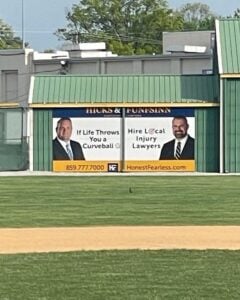 Photo of Hicks & Funfsinn advertisement on the Lafayette High School baseball field. 